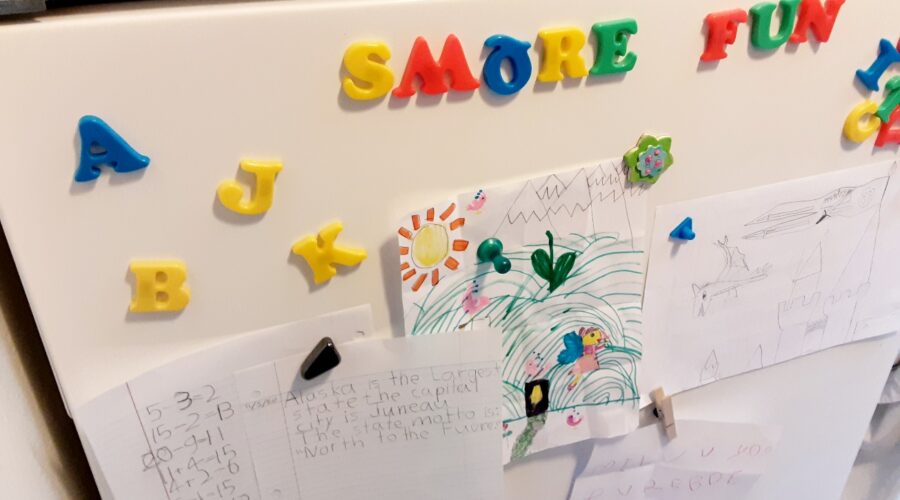 Refrigerator with letter magnets and children's artwork